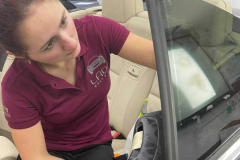 Lily working on tinting on of the rear windows of a vehicle