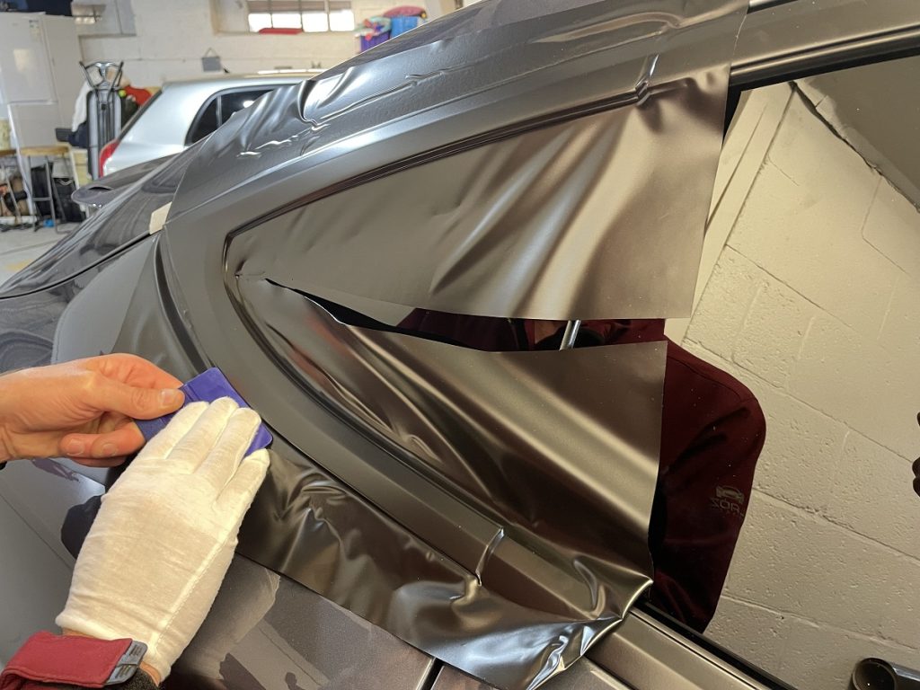 Tesla Model X SUV rear quarter dechrome in progress